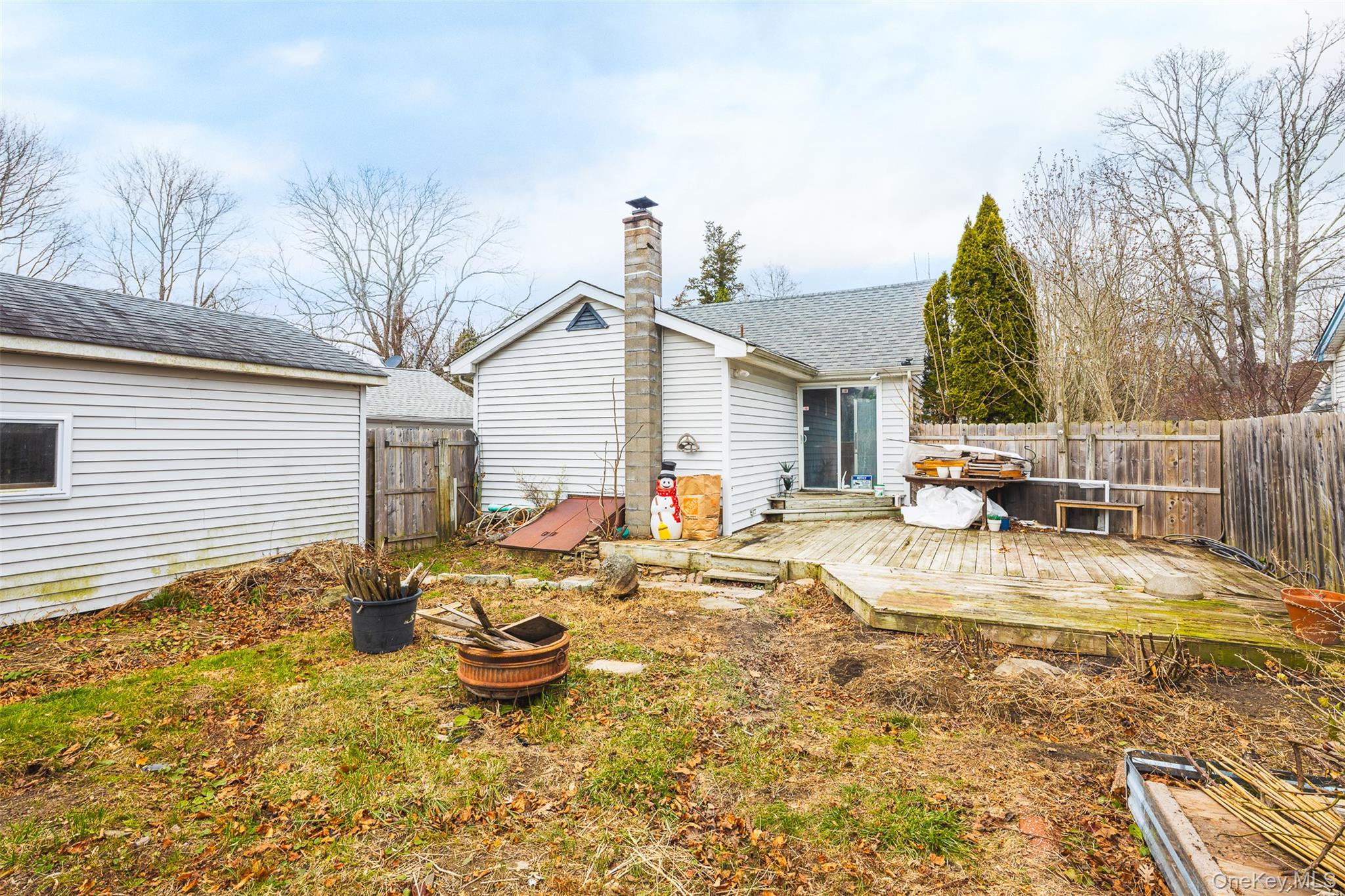 278 Elm Road West Mastic Beach, NY 11951 - Photo 12 of 14 a view of a backyard with table and chairs potted plants and wooden fence