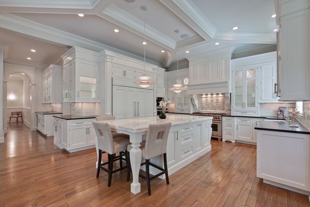 a kitchen with a table chairs wooden floors and view living room