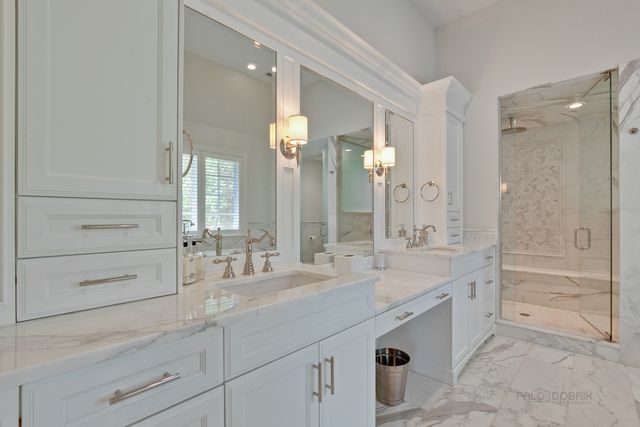 a bathroom with a double vanity sink mirror double and shower