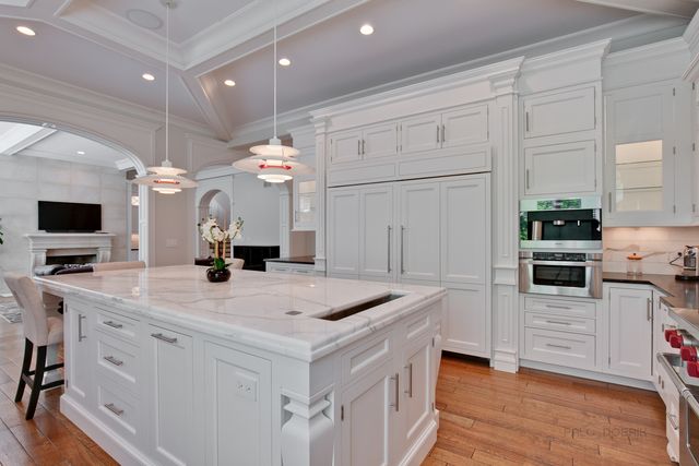 a kitchen with stainless steel appliances kitchen island granite countertop a sink a stove and a refrigerator