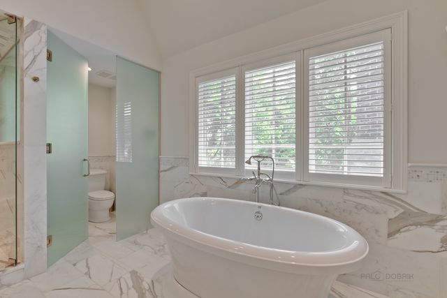 a white bath tub sitting next to a white toilet
