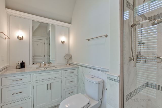 a en suite bathroom with a granite countertop sink toilet and shower