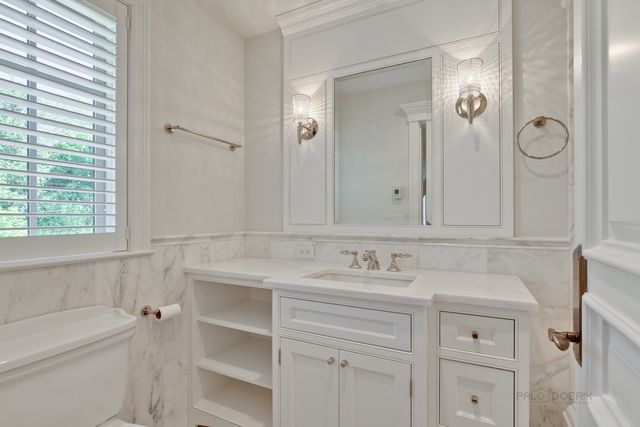 a bathroom with a sink vanity granite tub and a mirror