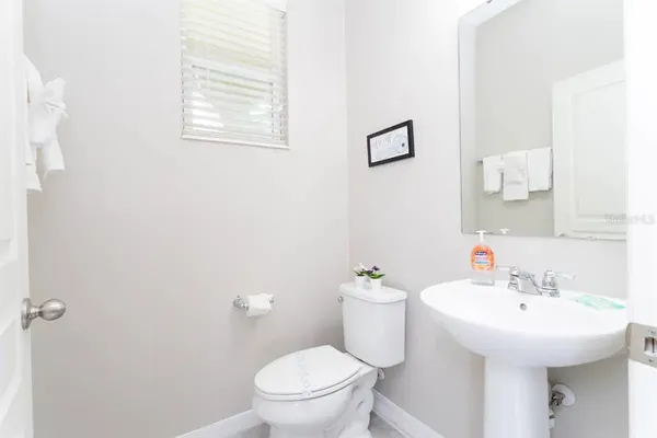 a bathroom with a granite countertop sink and a toilet