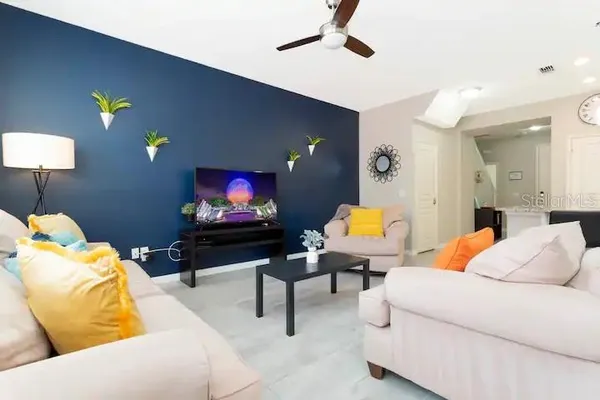a living room with furniture a lamp and a flat screen tv