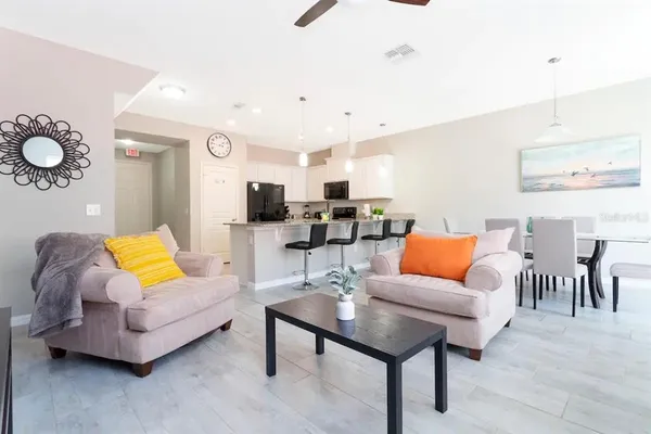 a living room with furniture kitchen view and a table