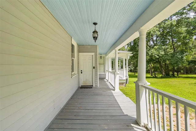 a view of a porch with wooden floor and fence