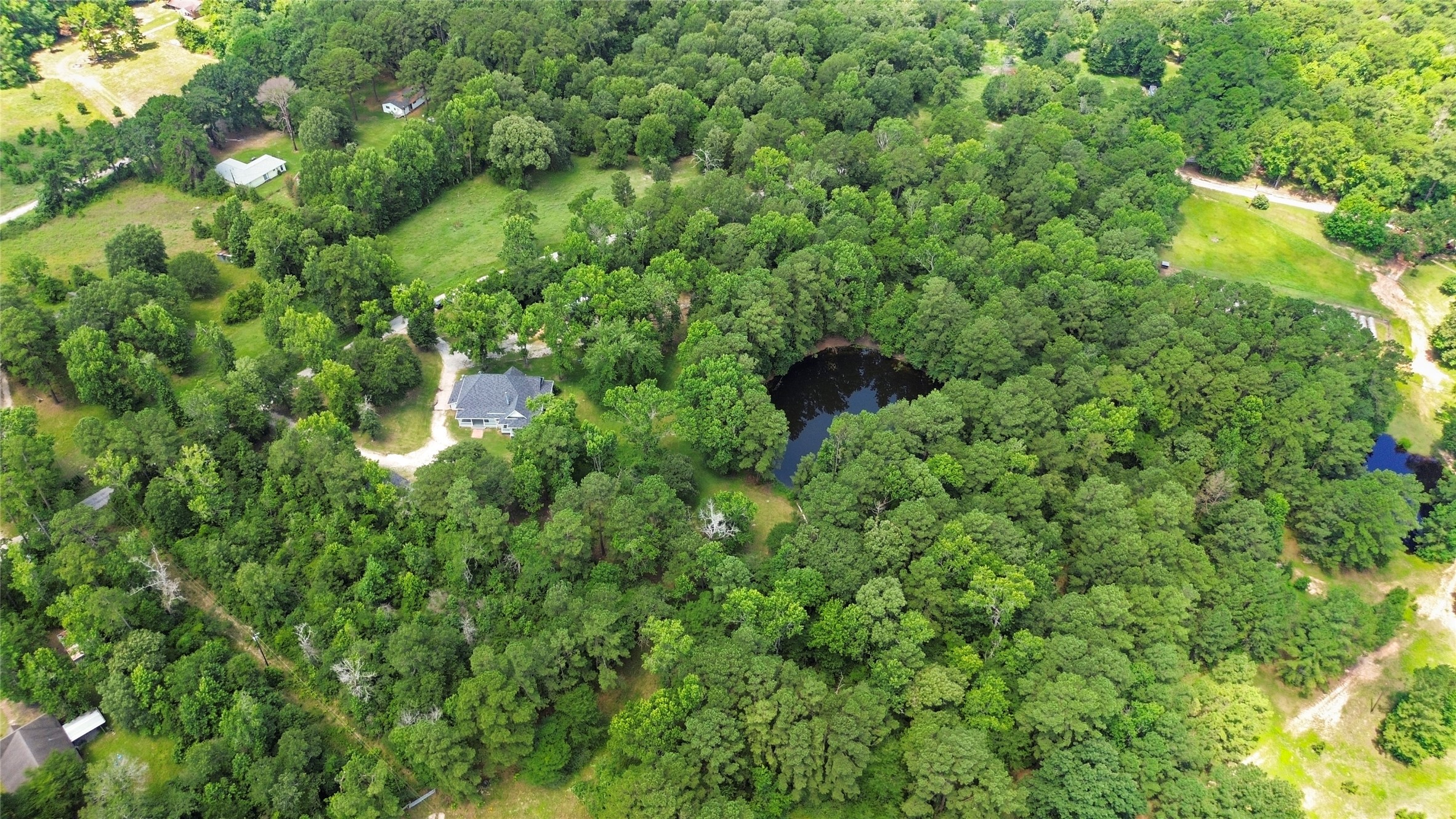 38 Darrell White Road Huntsville, TX 77340 - Photo 48 of 49 a backyard of a house with lots of green space and a fountain