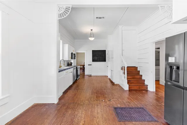 a view of a living room with wooden floor and a fireplace