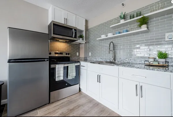 a kitchen with granite countertop stainless steel appliances and counter space
