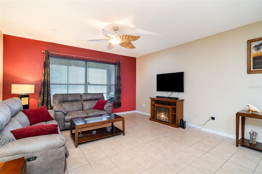 10903 Wildcat Drive Riverview, FL 33579 - Photo 13 of 45 a living room with furniture a flat screen tv and a fireplace