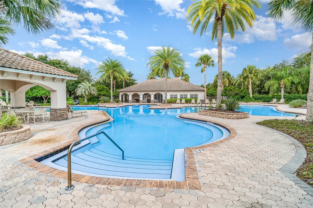 10903 Wildcat Drive Riverview, FL 33579 - Photo 38 of 45 a view of a swimming pool with lawn chairs under an umbrella