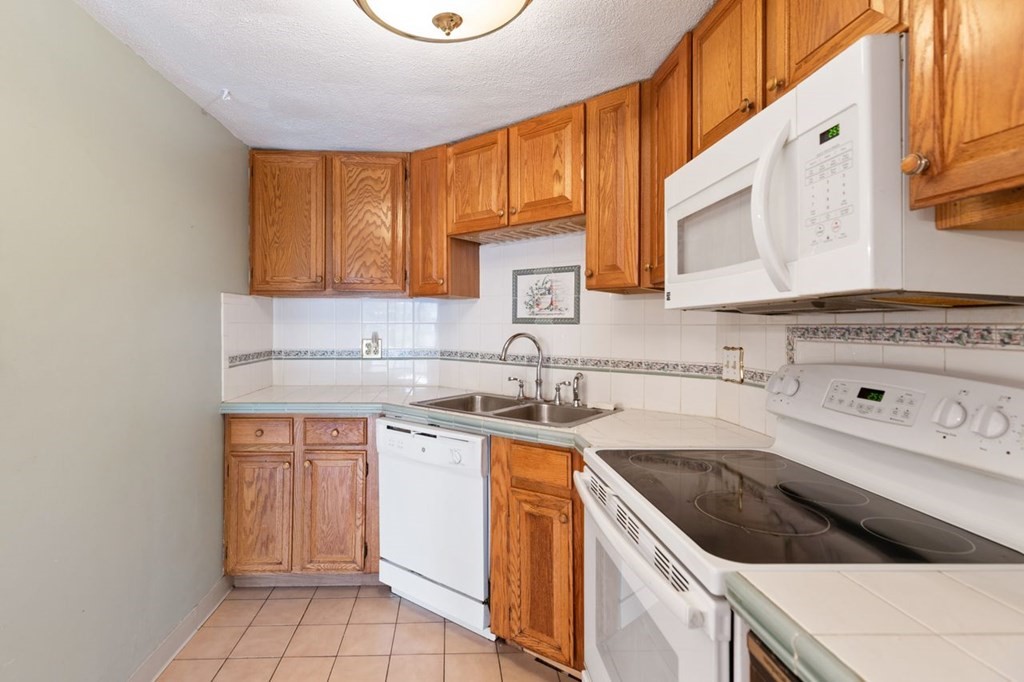205 Ferry Street, Unit 409 Everett, MA 02149 - Photo 12 of 24 a kitchen with a sink stove and cabinets