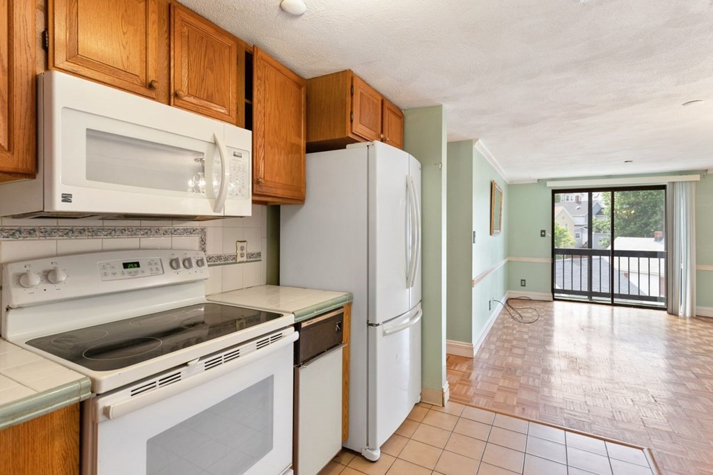 205 Ferry Street, Unit 409 Everett, MA 02149 - Photo 13 of 24 a kitchen with a stove cabinets and a refrigerator