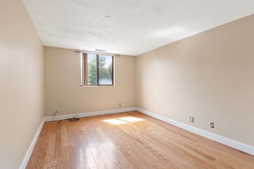 205 Ferry Street, Unit 409 Everett, MA 02149 - Photo 18 of 24 an empty room with wooden floor and windows