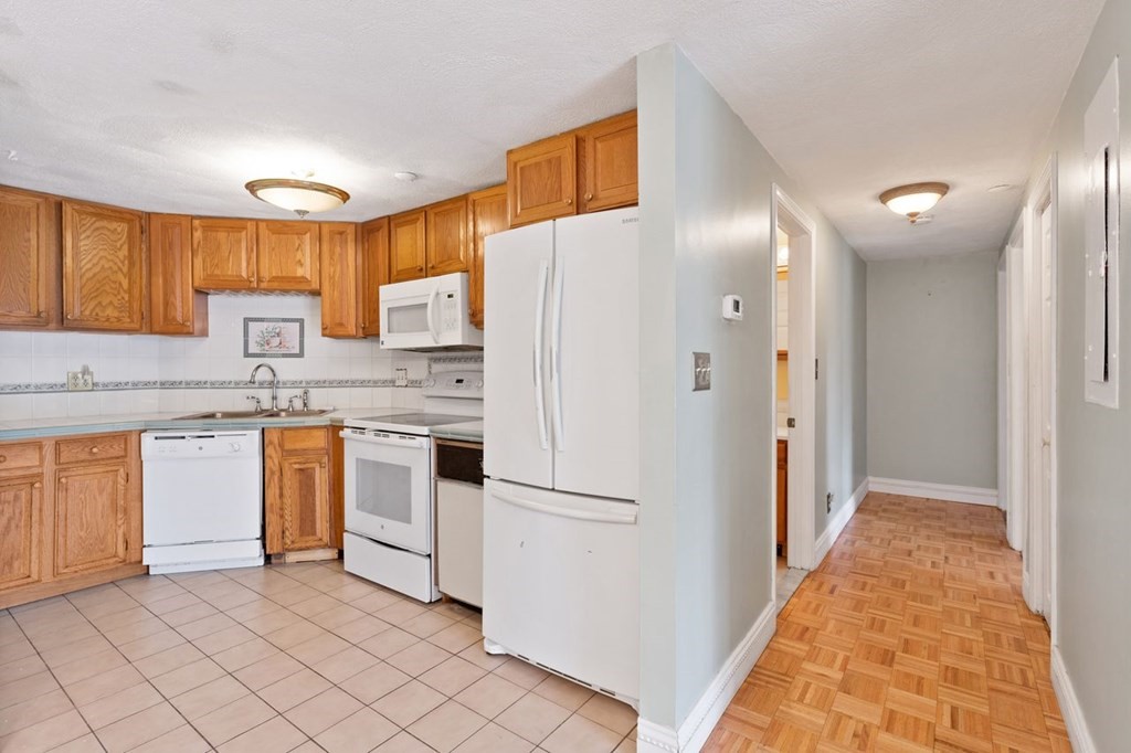 205 Ferry Street, Unit 409 Everett, MA 02149 - Photo 10 of 24 a kitchen with white cabinets and white appliances