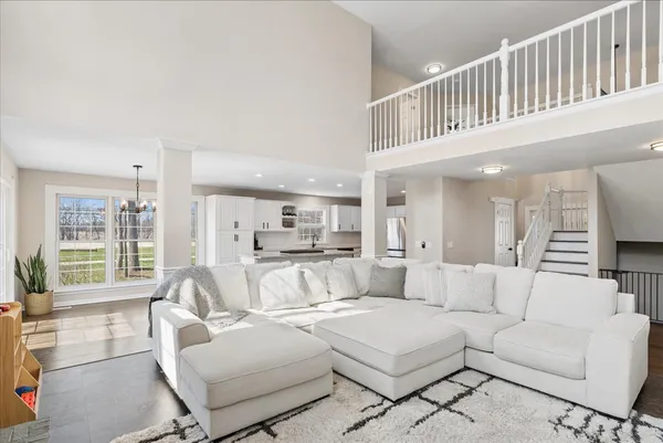 a living room with furniture a large window and a chandelier