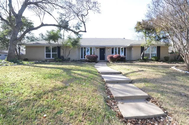 a view of a house with a yard and trees