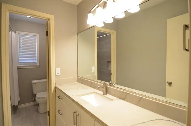 a bathroom with a double vanity sink toilet and shower