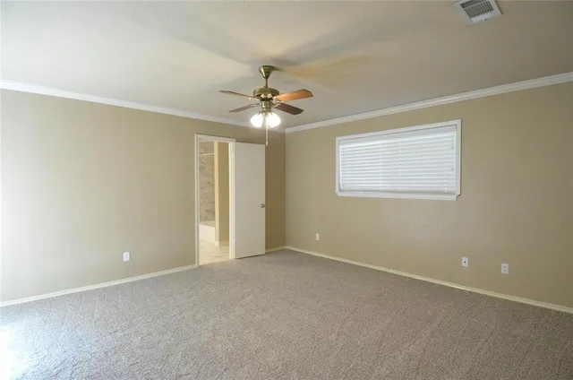 an empty room with chandelier fan and windows