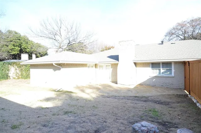 a view of an house with backyard and trees