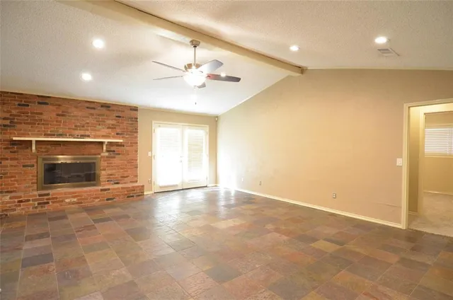 an empty room with a fireplace and fan