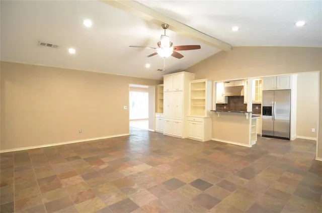 a view of empty room with wooden floor and a ceiling fan