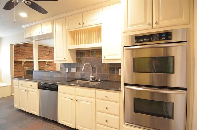a kitchen with granite countertop white cabinets stainless steel appliances and sink