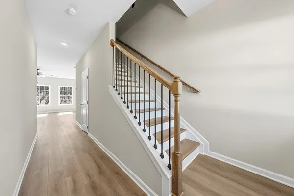 a view of a hallway with wooden floor and staircase