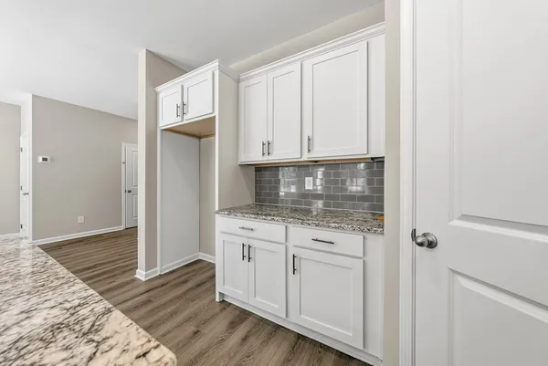 a kitchen with stainless steel appliances granite countertop a refrigerator and white cabinets