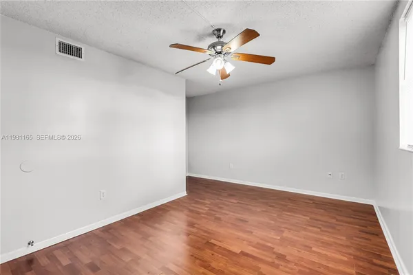 a view of an empty room with wooden floor