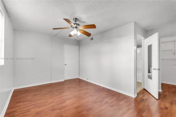 a view of an empty room with wooden floor