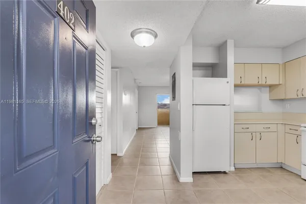 a view of a kitchen with refrigerator and cabinet