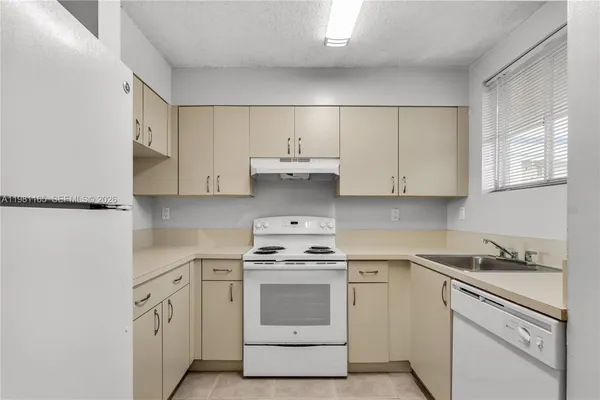 a kitchen with white cabinets and white appliances