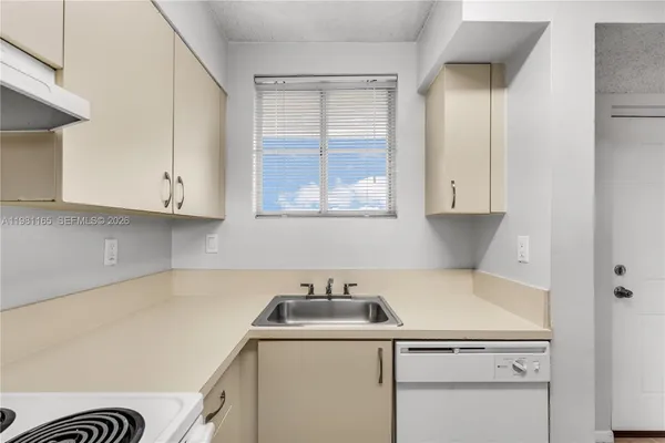 a view of a kitchen with sink and cabinets