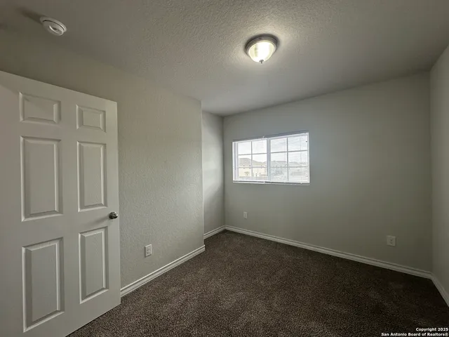 an empty room with closet and windows