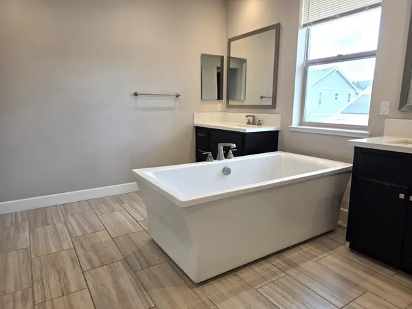 a white bath tub sitting in a bathroom next to a window