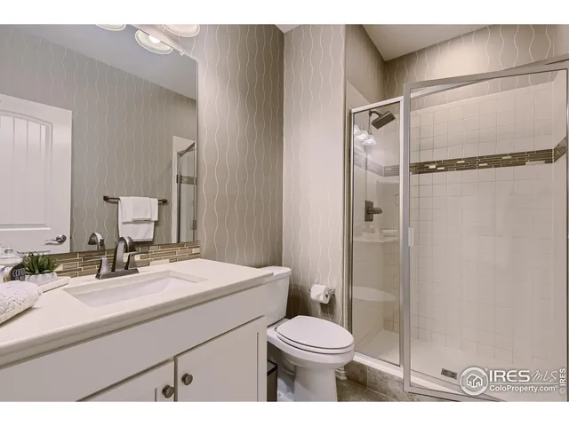 a bathroom with a sink toilet vanity and shower