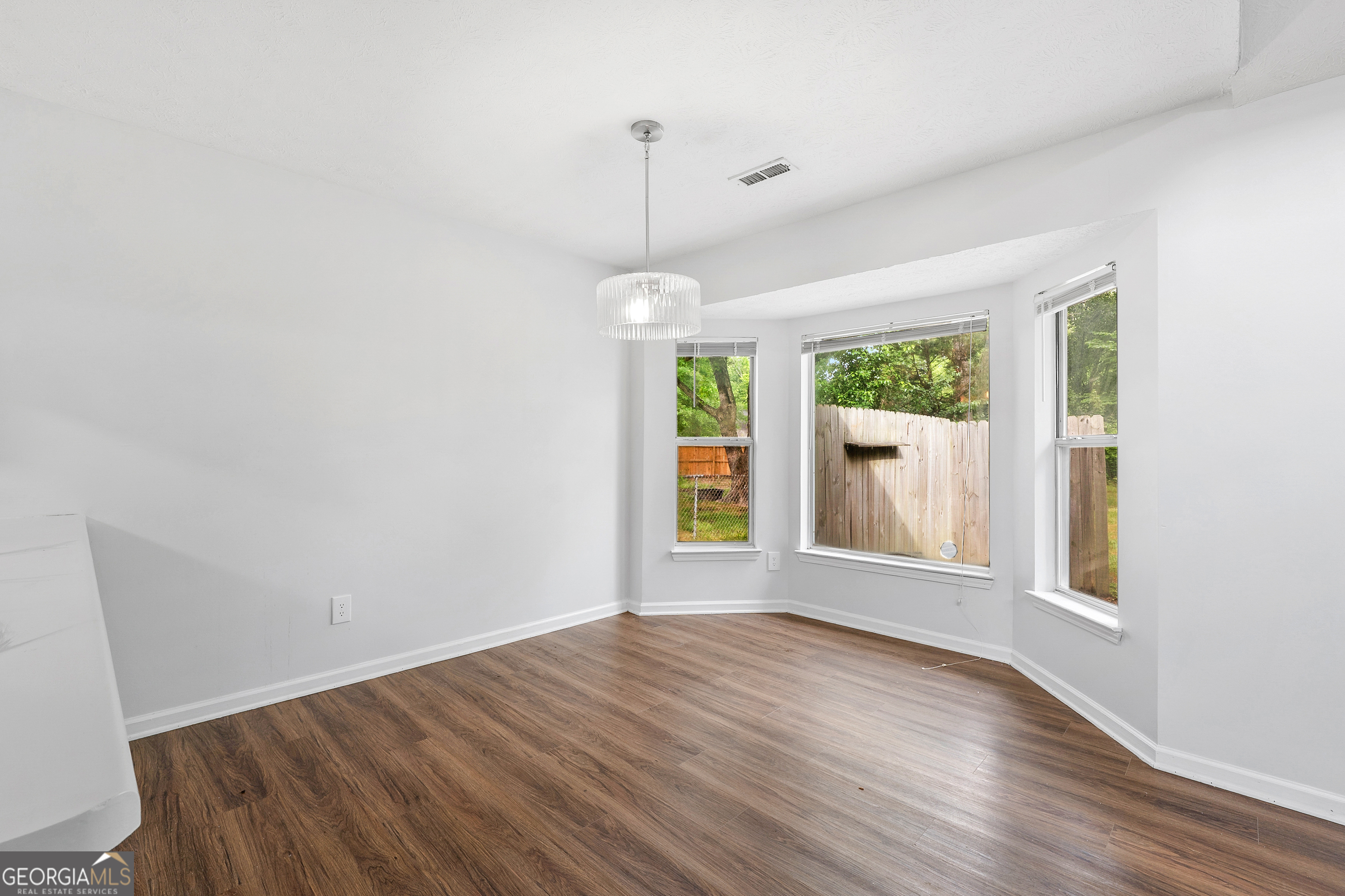 1328 Foxvale Drive Hampton, GA 30228 - Photo 11 of 27 a view of an empty room with wooden floor and a window