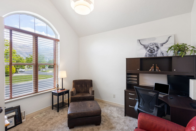882 Sego Lily Way Mapleton, UT 84664 - Photo 4 of 41 Arched window with wood-finish blinds, vaulted ceiling, built-in desk cabinetry, and neutral carpet flooring