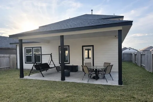 a view of a house with backyard and sitting area