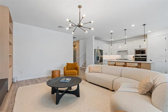 a living room with furniture and a view of kitchen