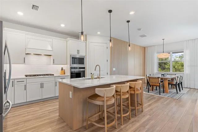 a kitchen with stainless steel appliances granite countertop a stove a sink and a refrigerator