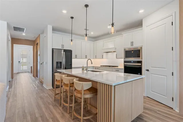 a kitchen with white cabinets stainless steel appliances and sink