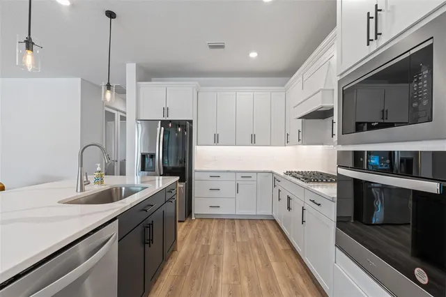 a kitchen that has a lot of counter space and wooden floor