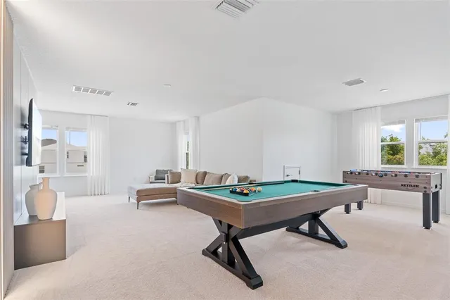 a room with pool table and windows