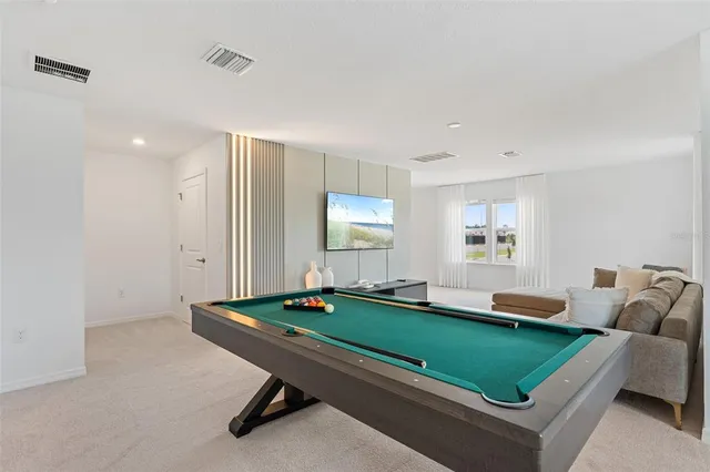 a room with furniture pool table and windows