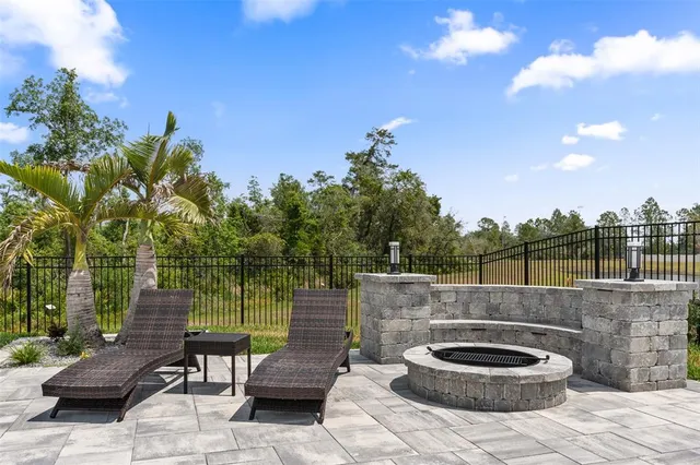 a view of a patio with table and chairs with wooden floor and fence
