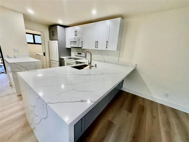 a kitchen with a sink a stove and cabinets