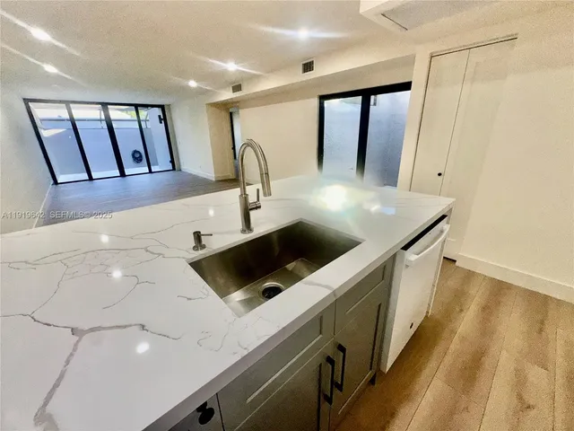 a kitchen with kitchen island a sink stainless steel appliances and cabinets